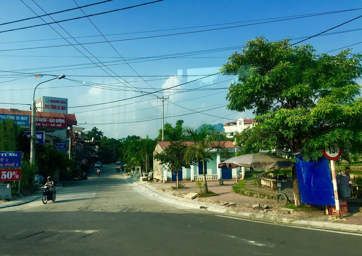 Đường phố với xe máy, nhà thấp tầng và cây xanh tại Tuyên Quang